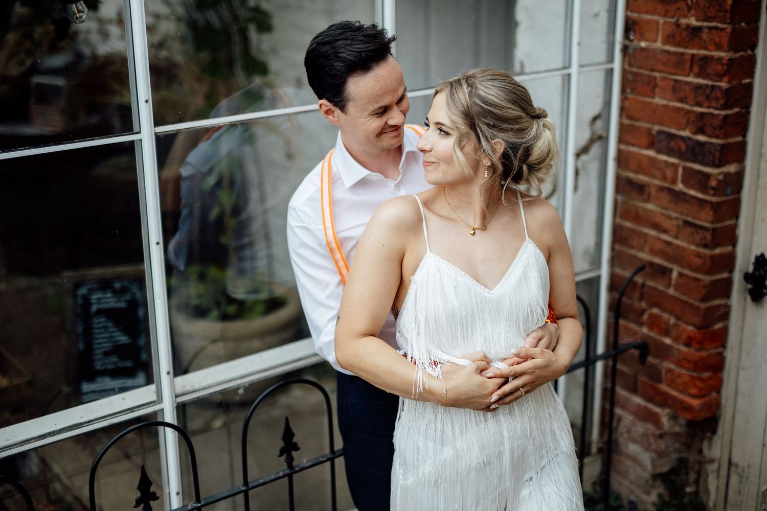 Romantic moment by a vintage window with brick wall background.