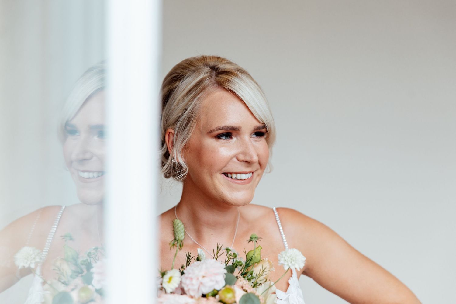 Bridal portrait with soft natural window lighting and delicate floral details.