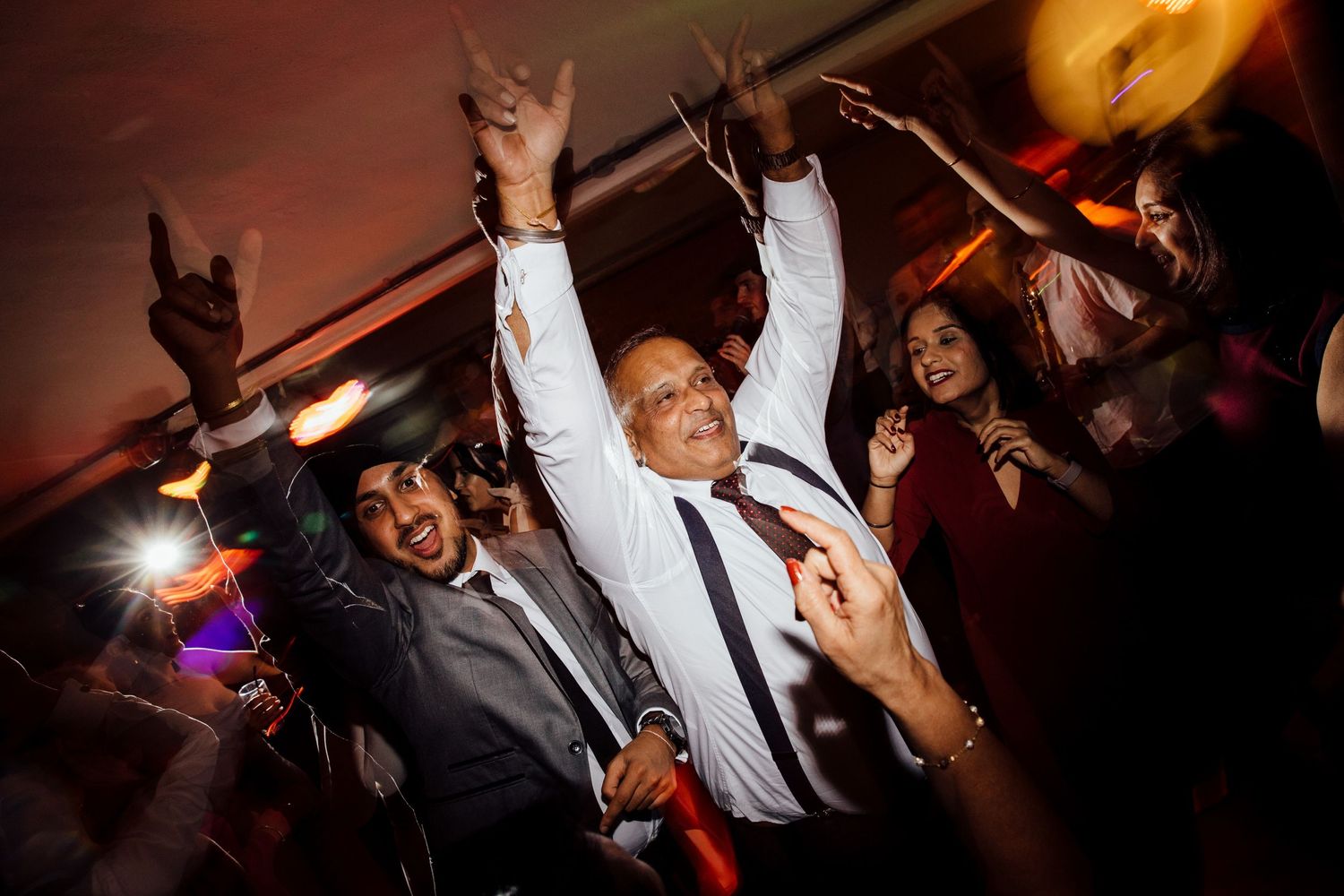 Wedding reception dance floor filled with energetic party guests.