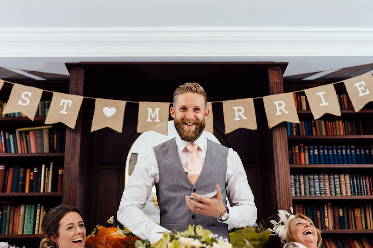 Wedding reception setup in a cozy library with rustic banner decorations.