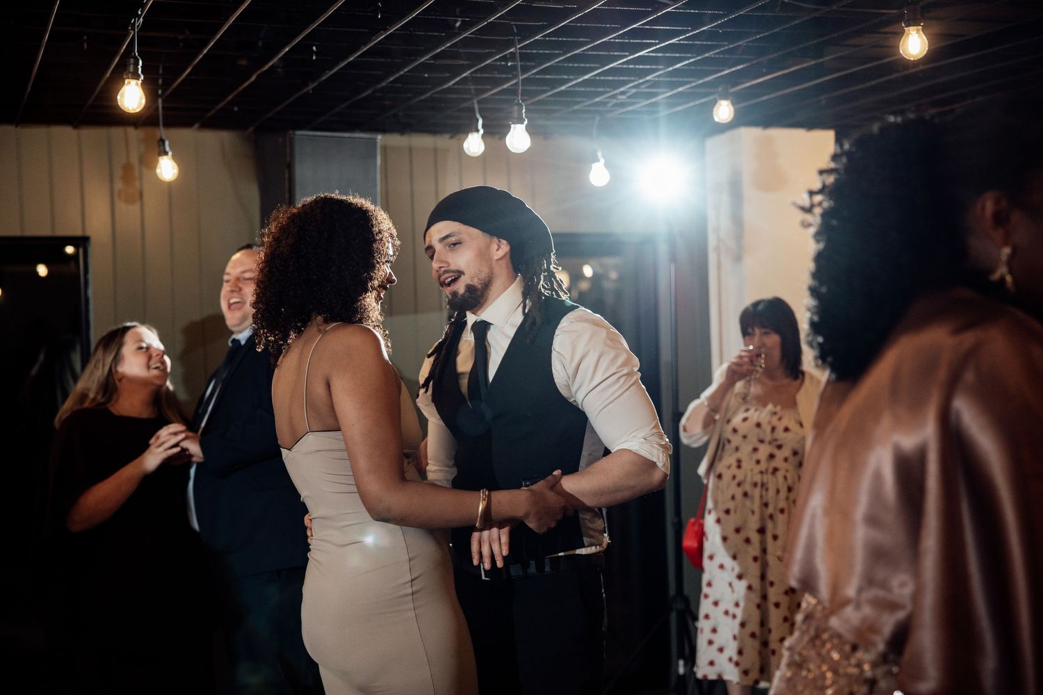 Couple sharing an intimate dance together at a warmly lit wedding reception party.