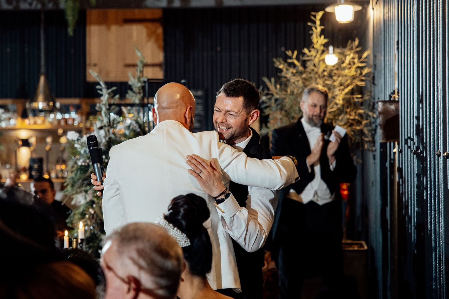 Wedding celebration at an indoor venue with warm lighting and festive atmosphere.