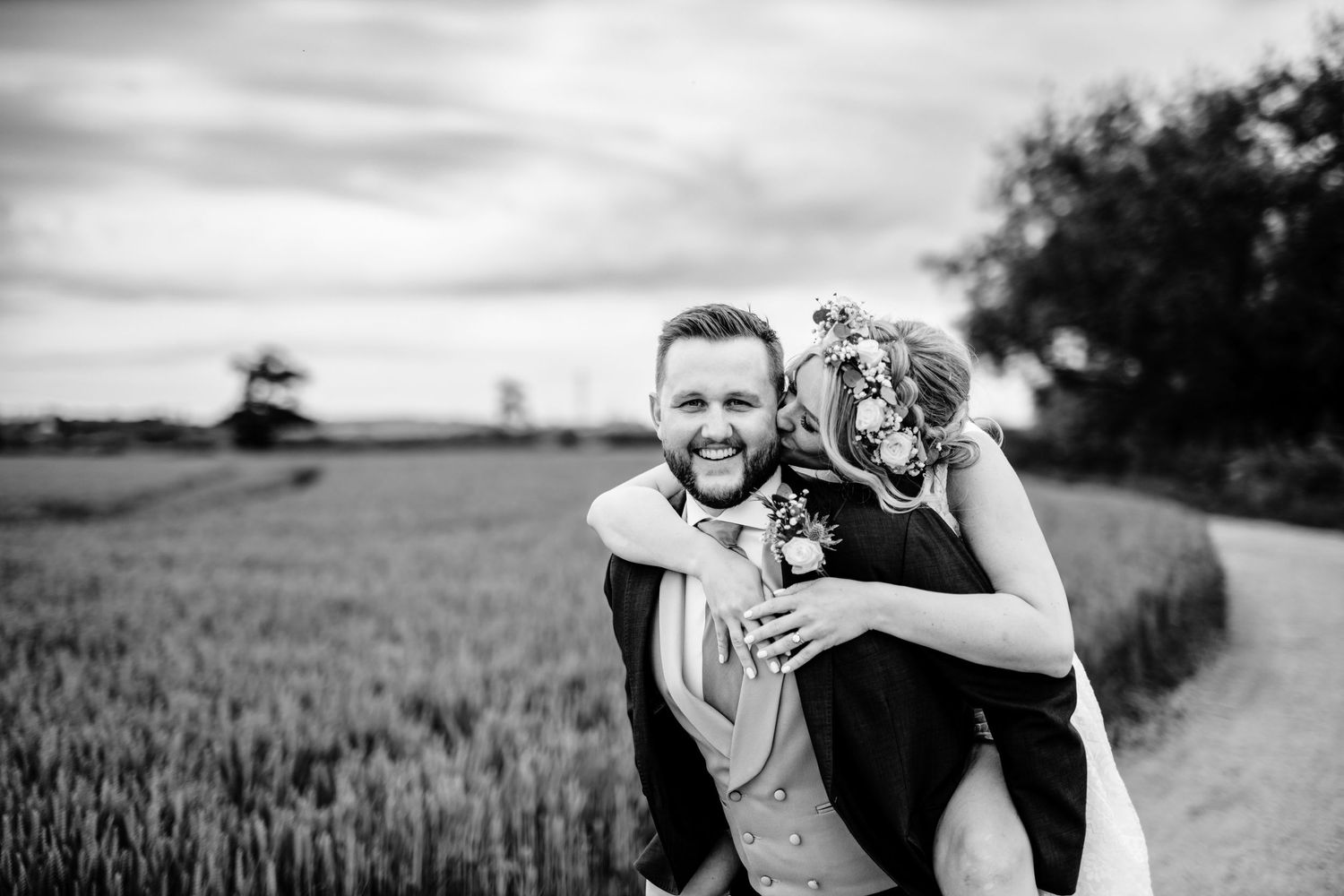 Black and white candid moment captured in wheat field at sunset.