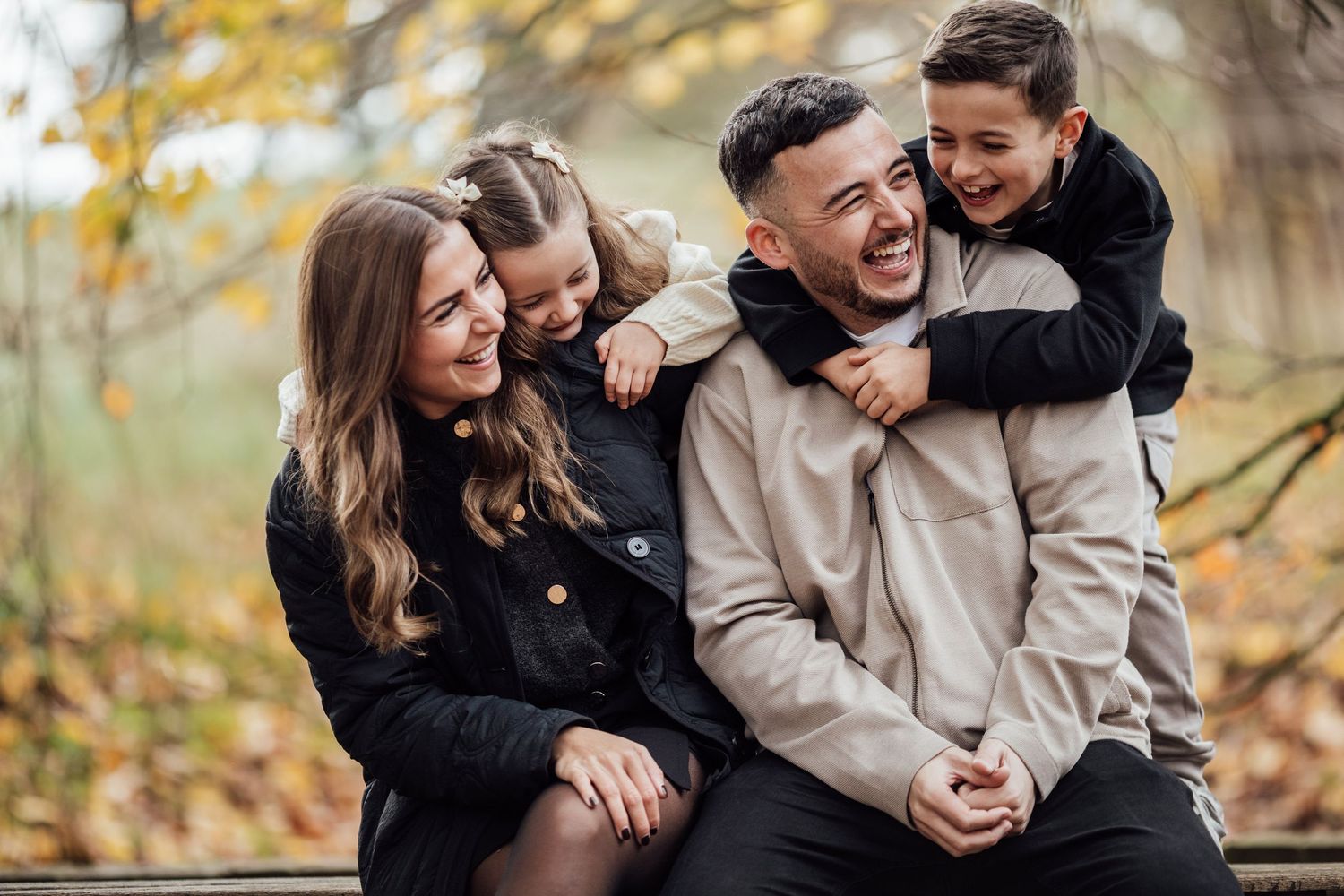 Joyful autumn family portrait with playful interactions outdoors.