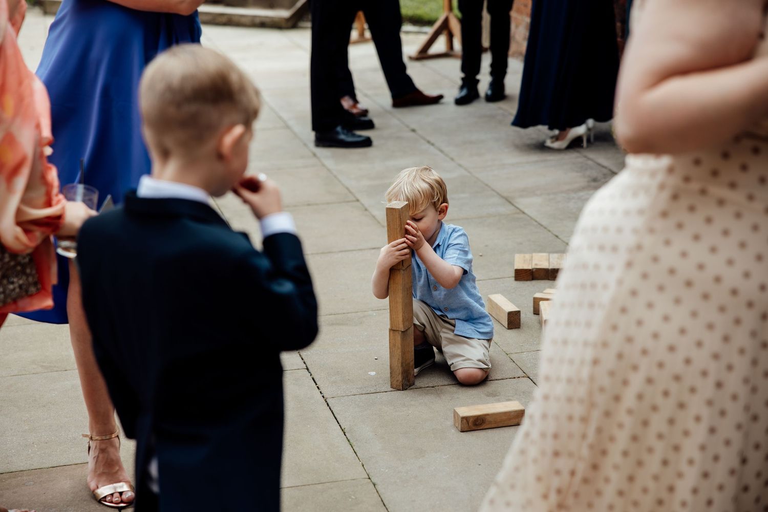 Young children playing with wooden games during wedding reception.