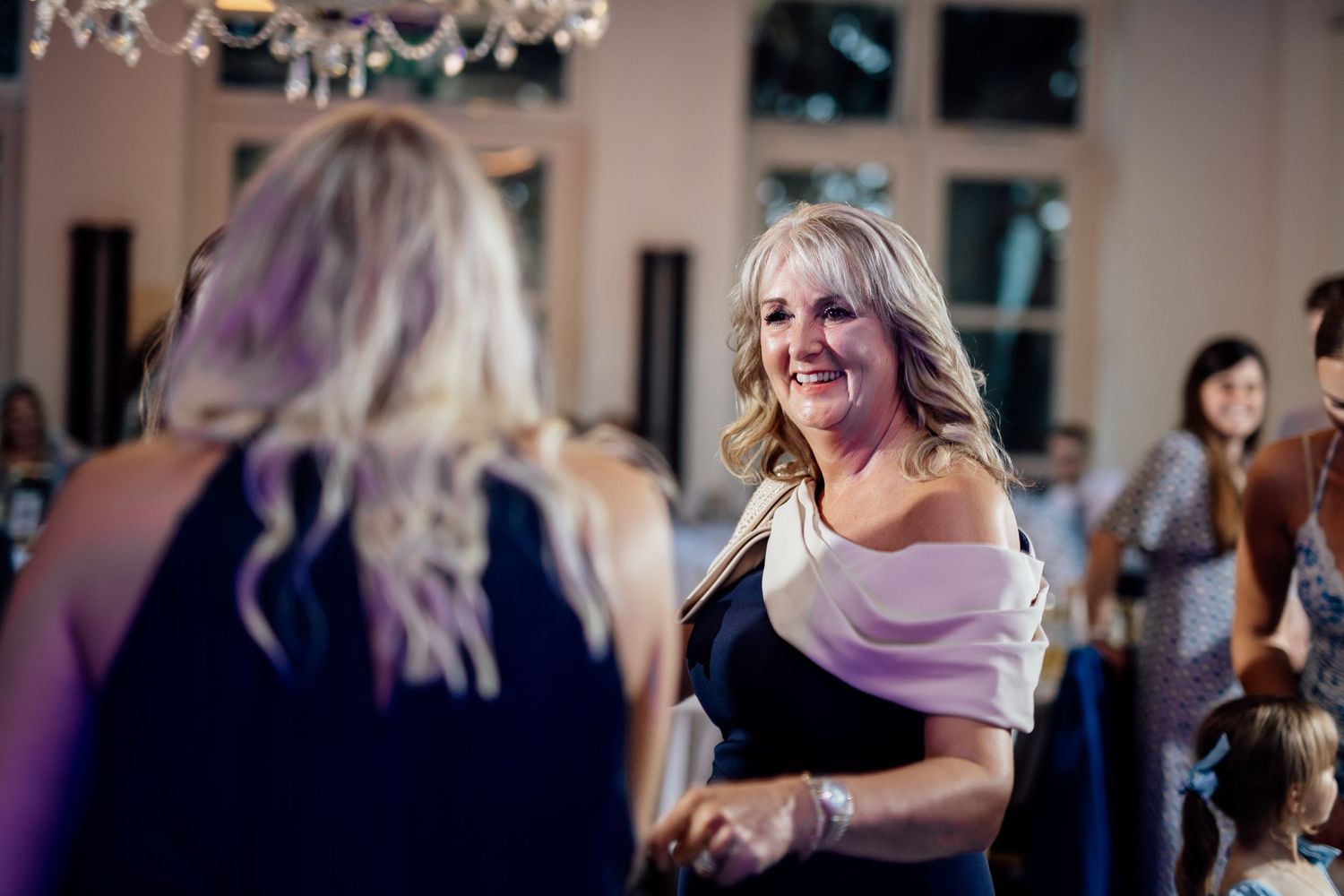 Guests dancing and celebrating at an indoor wedding reception.