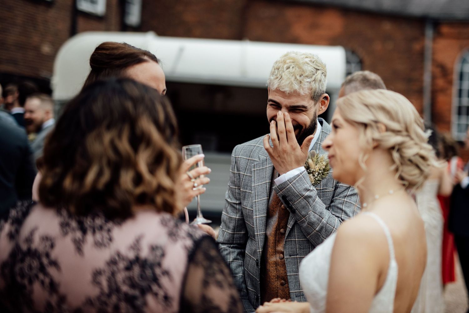 Wedding guests dancing and celebrating at reception with festive atmosphere.