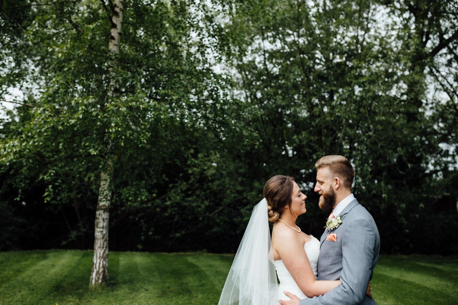 A romantic wedding moment captured in a lush green garden setting.