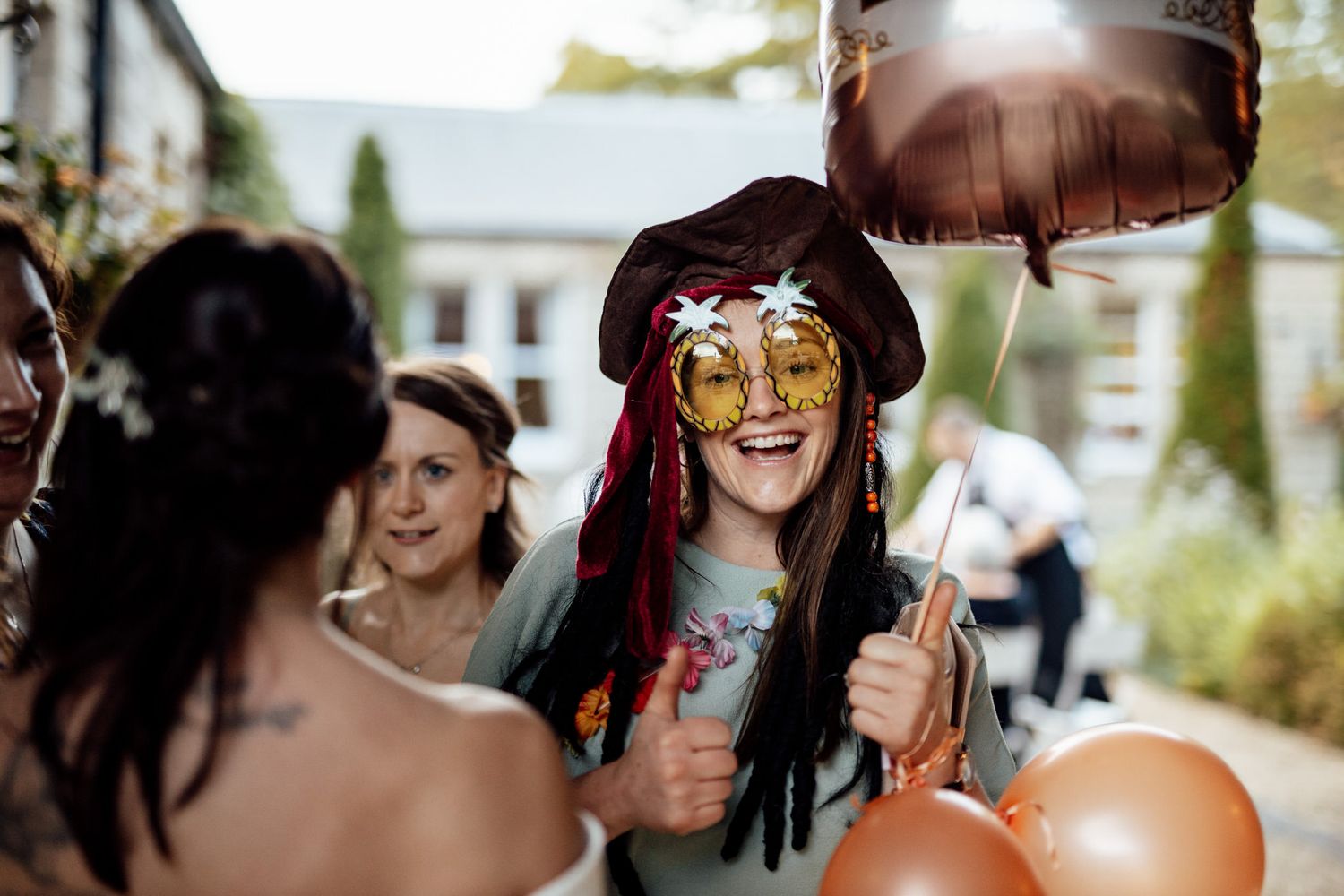 Wedding party members posing with sunglasses in bright outdoor lighting.