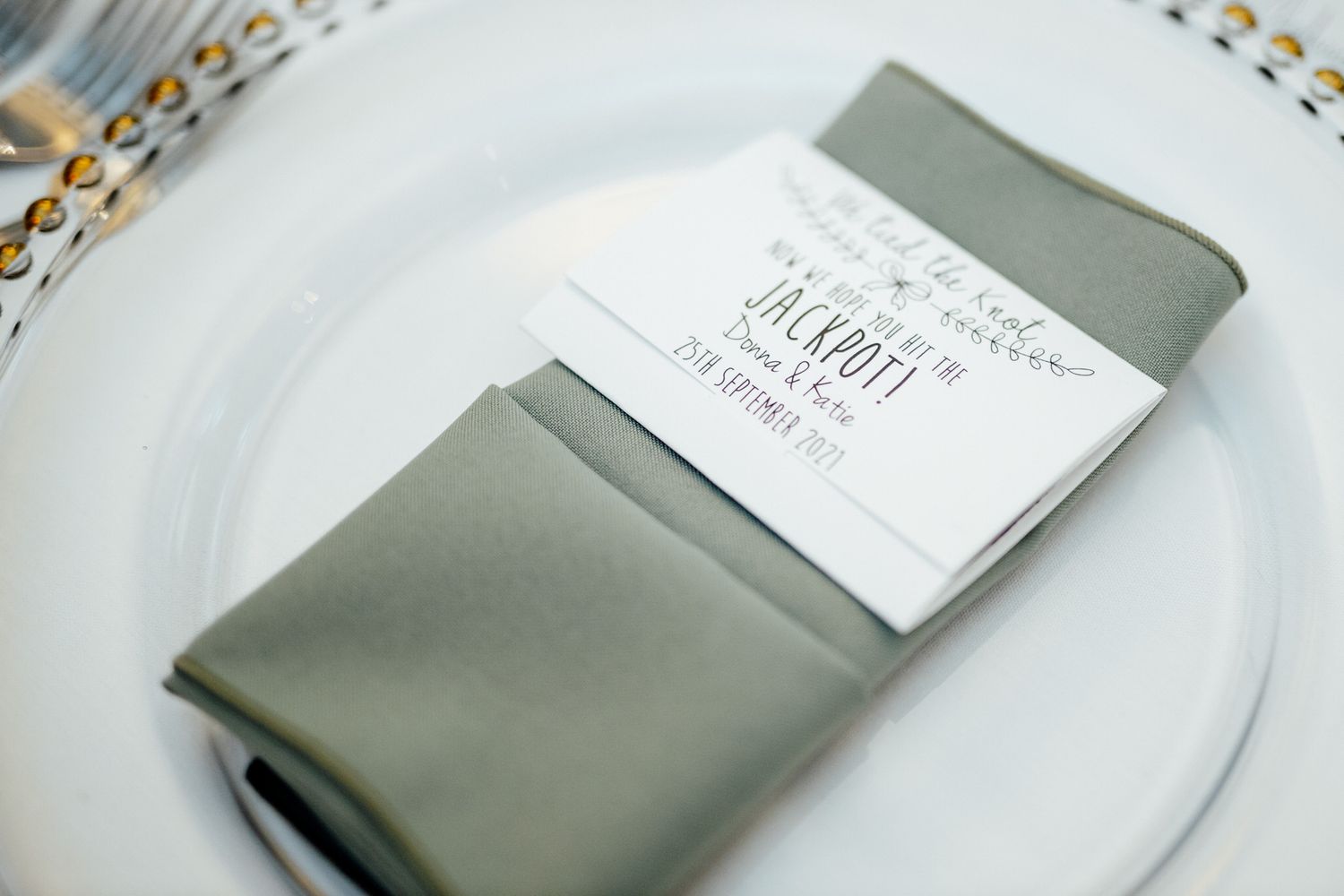 Place settings with gray napkins and menu cards on white plates.