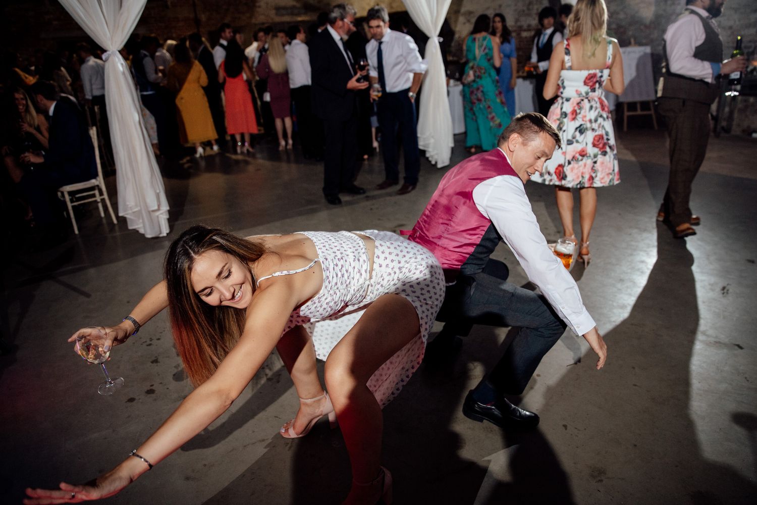 Wedding reception dance floor filled with guests enjoying energetic dancing.