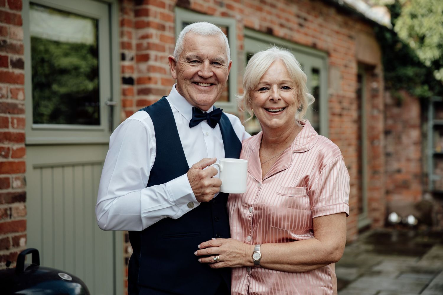 Guests in formal attire sharing joyful moments at a brick venue.