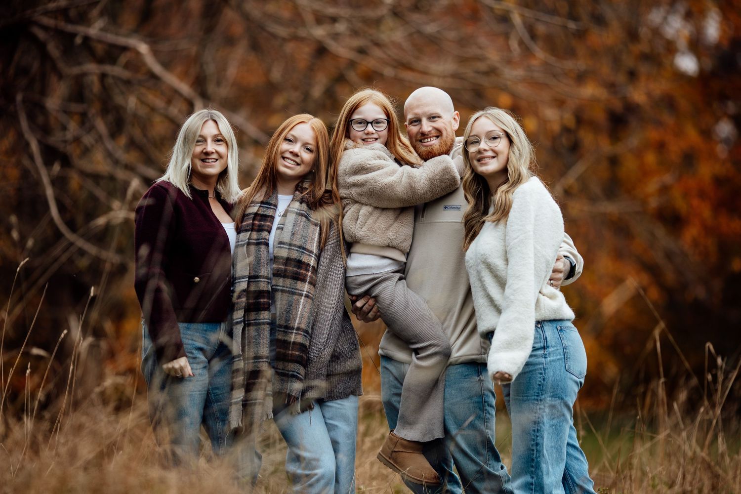 Group of friends posing together outdoors during autumn season.