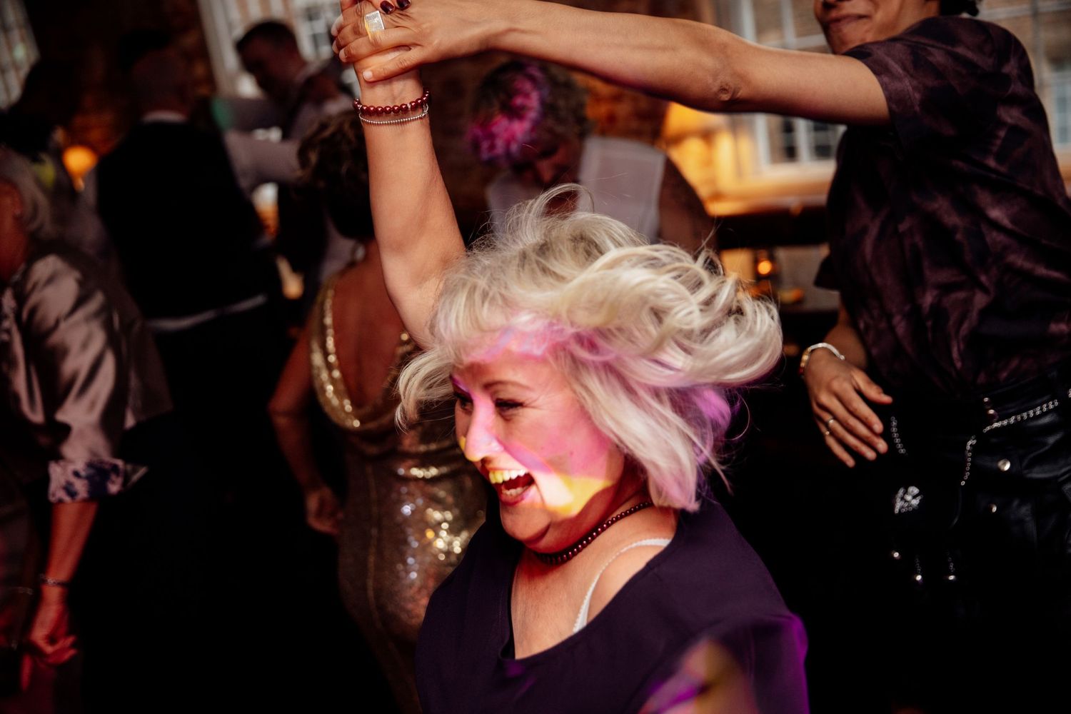 Wedding reception dance floor filled with guests enjoying lively celebration.
