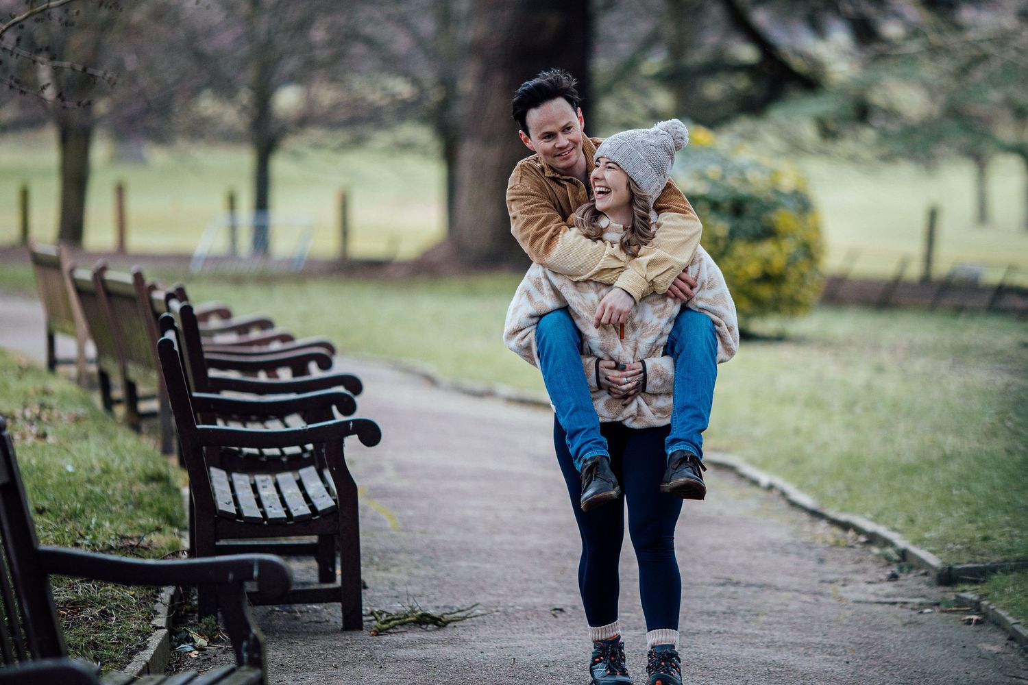 Sweet candid moments captured on park benches during a winter photo session.