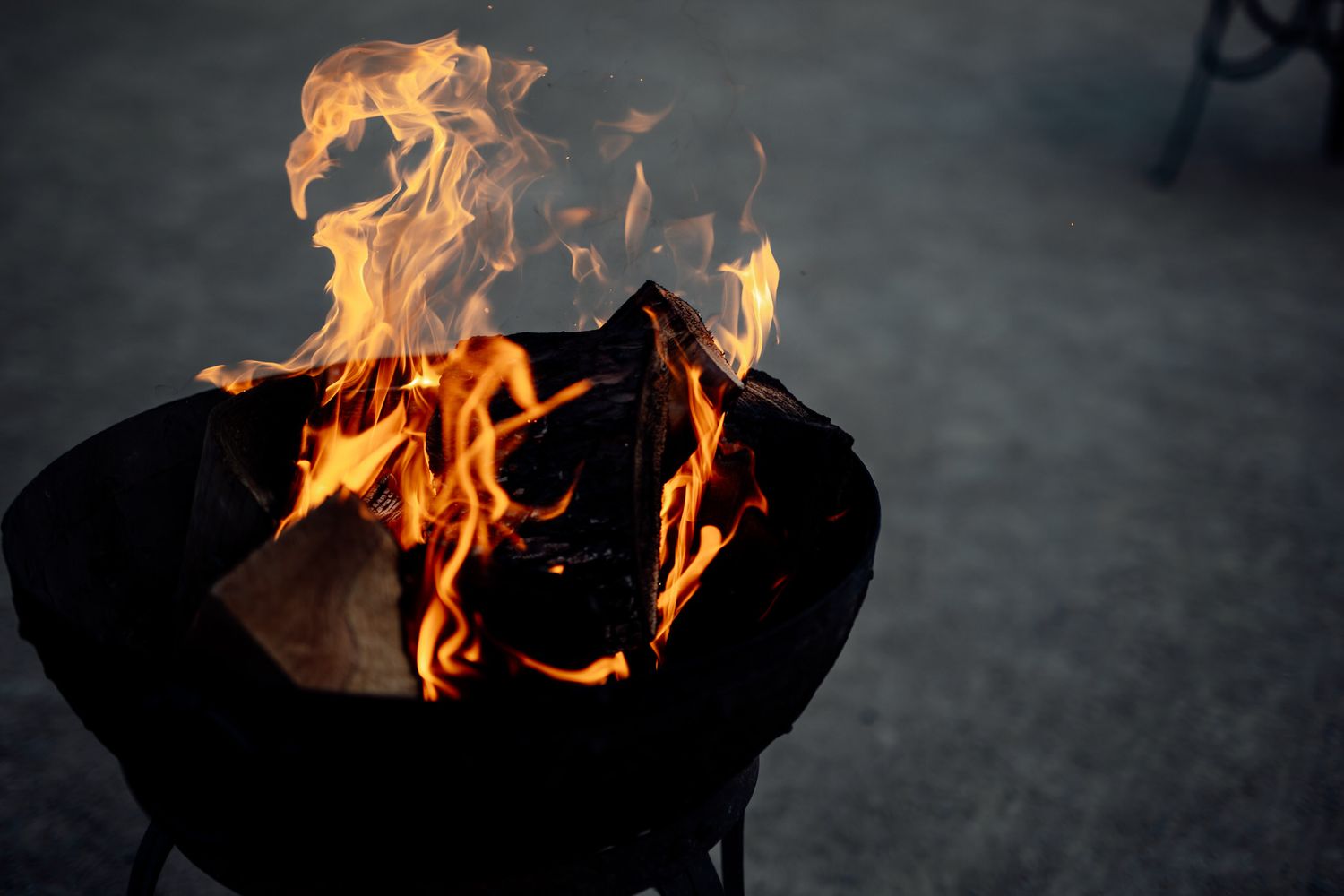 Dramatic flames burning against a dark background at an outdoor event.