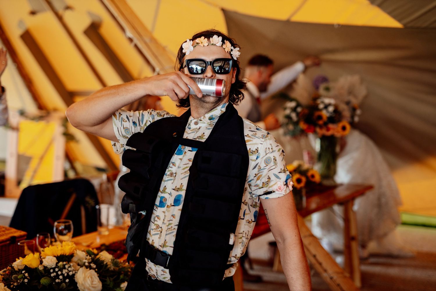 Party guest wearing a decorative mask dances at a festive tent reception.