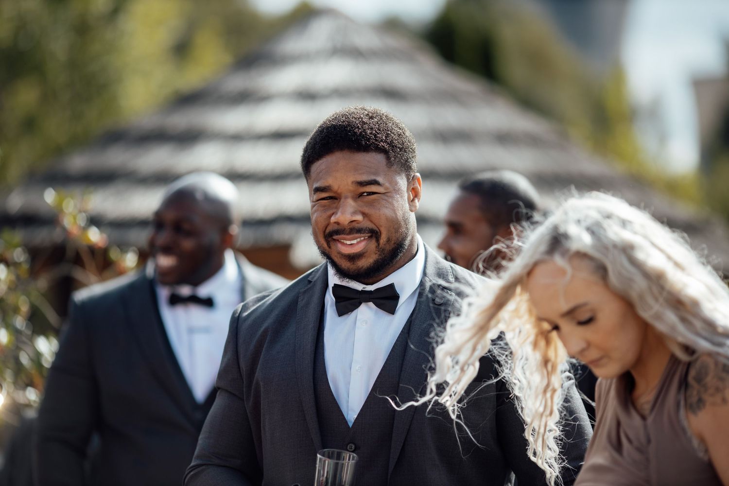 Wedding party shares joyful moments during outdoor photo session.