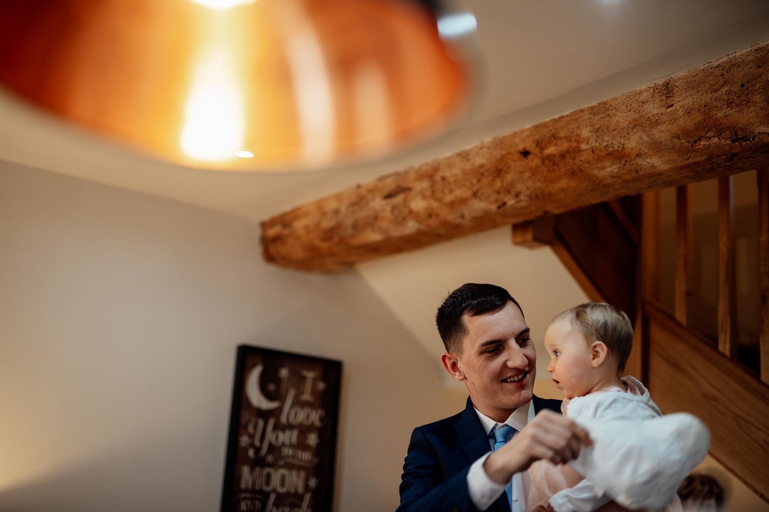 Intimate wedding reception moments captured in warm lighting under wooden beams.