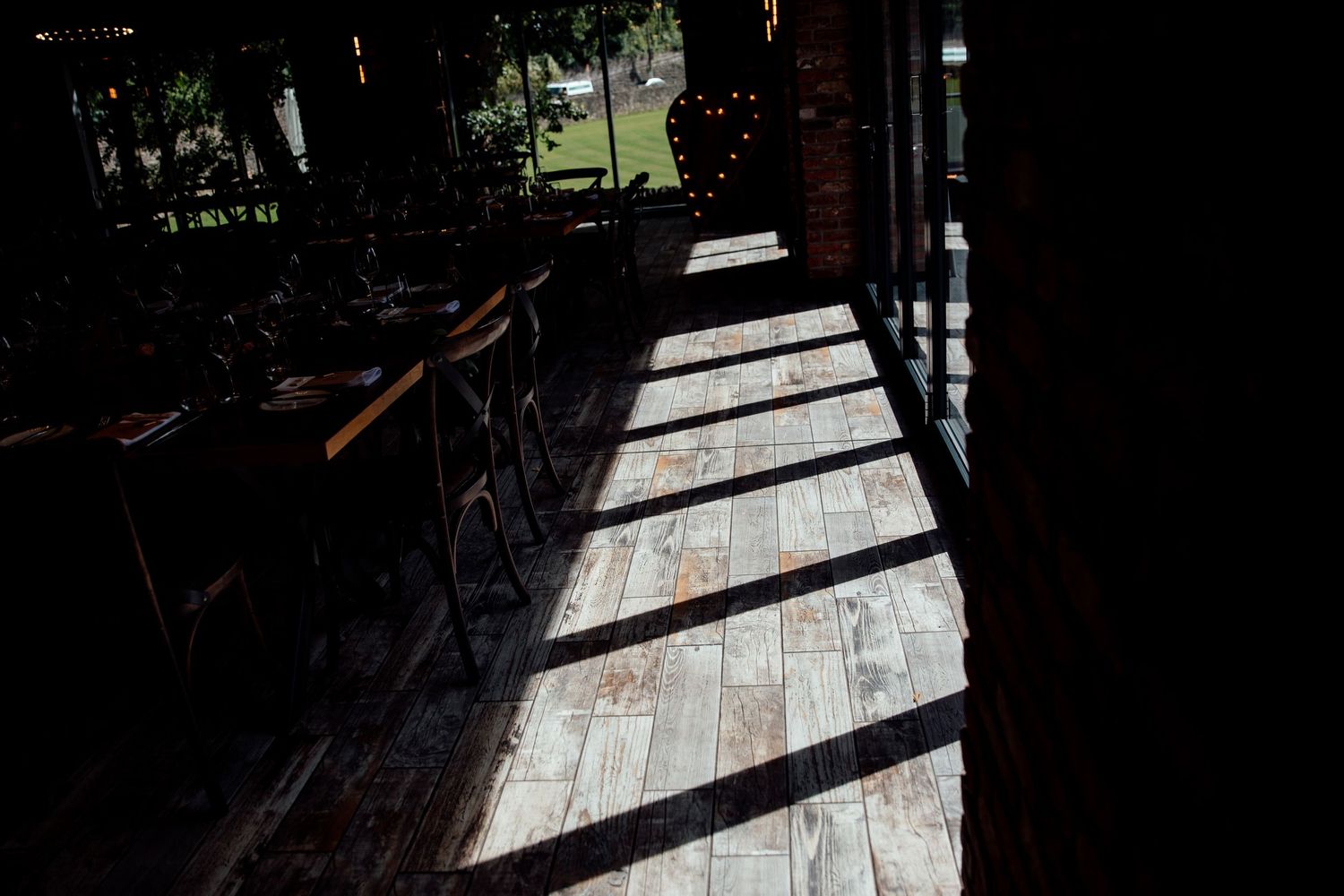 Dramatic shadows cast on stone patio through outdoor reception tent.
