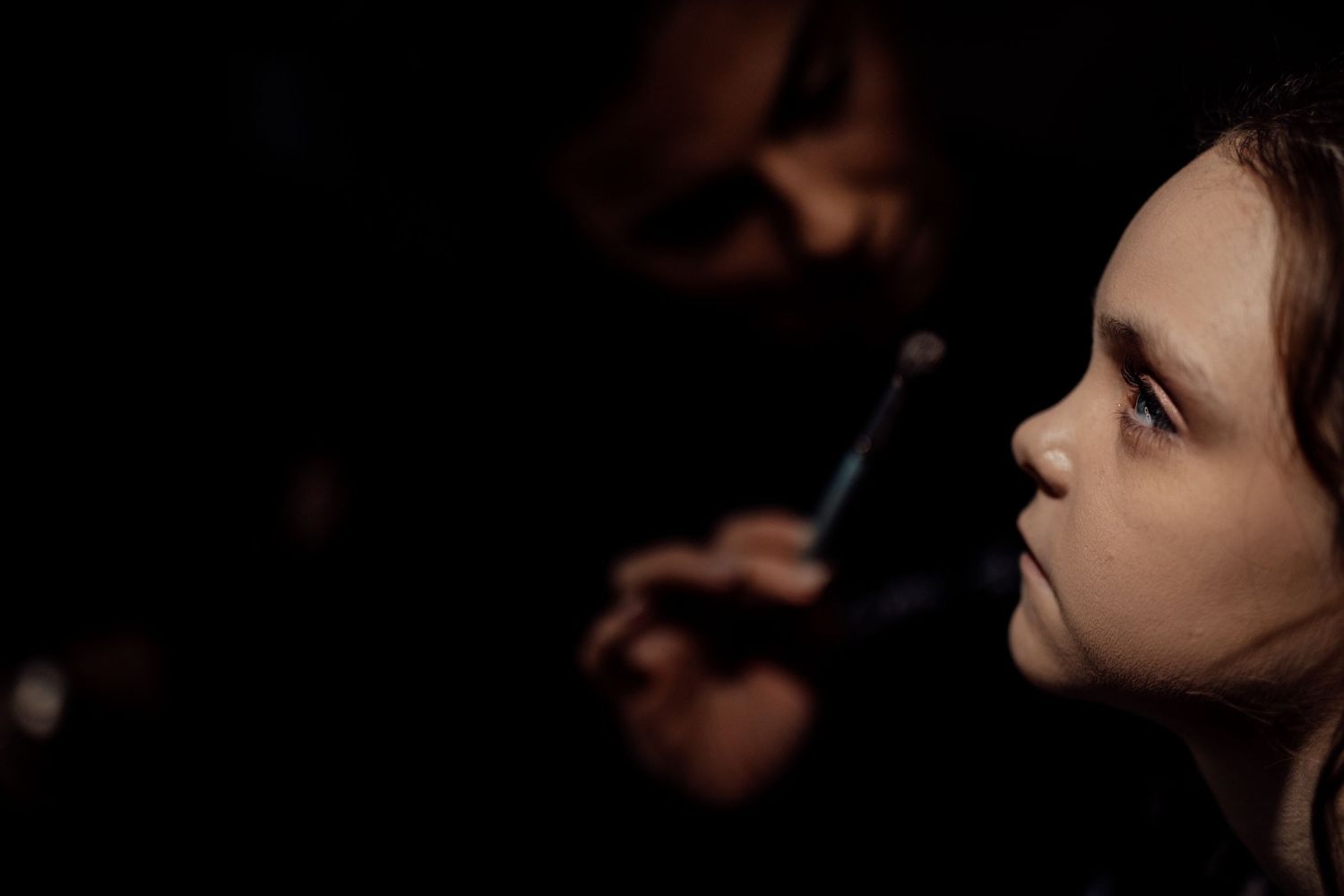 Dramatic low-light portrait with artistic shadows and lighting.