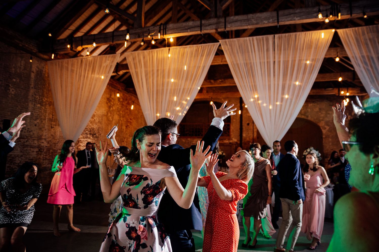 Wedding reception venue decorated with flowing white drapes and string lights creating an elegant atmosphere.