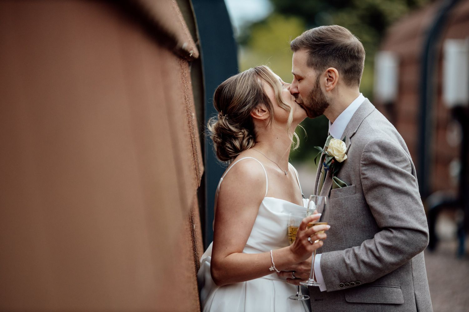 Romantic wedding couple embraces in multiple intimate poses against a natural outdoor backdrop.