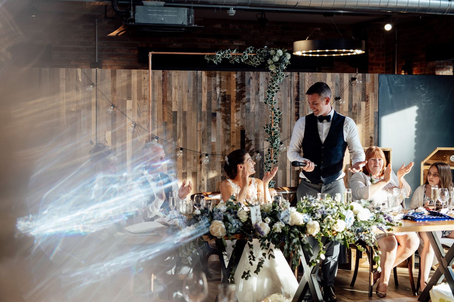 Wedding reception venue with rustic wooden beams and romantic lighting.