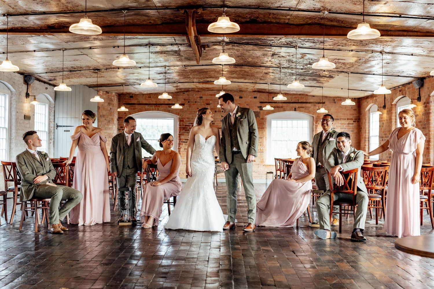 Wedding reception in a rustic venue with hanging lights and exposed wooden beams.