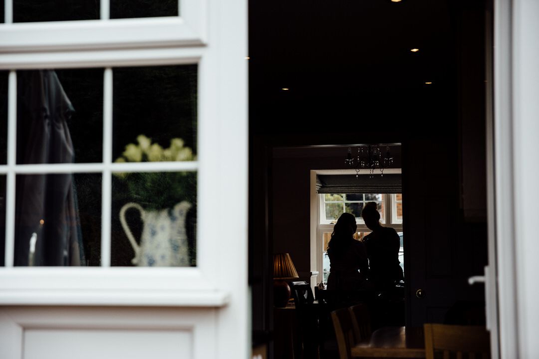 Silhouetted figures visible through dark doorway with window display in foreground.