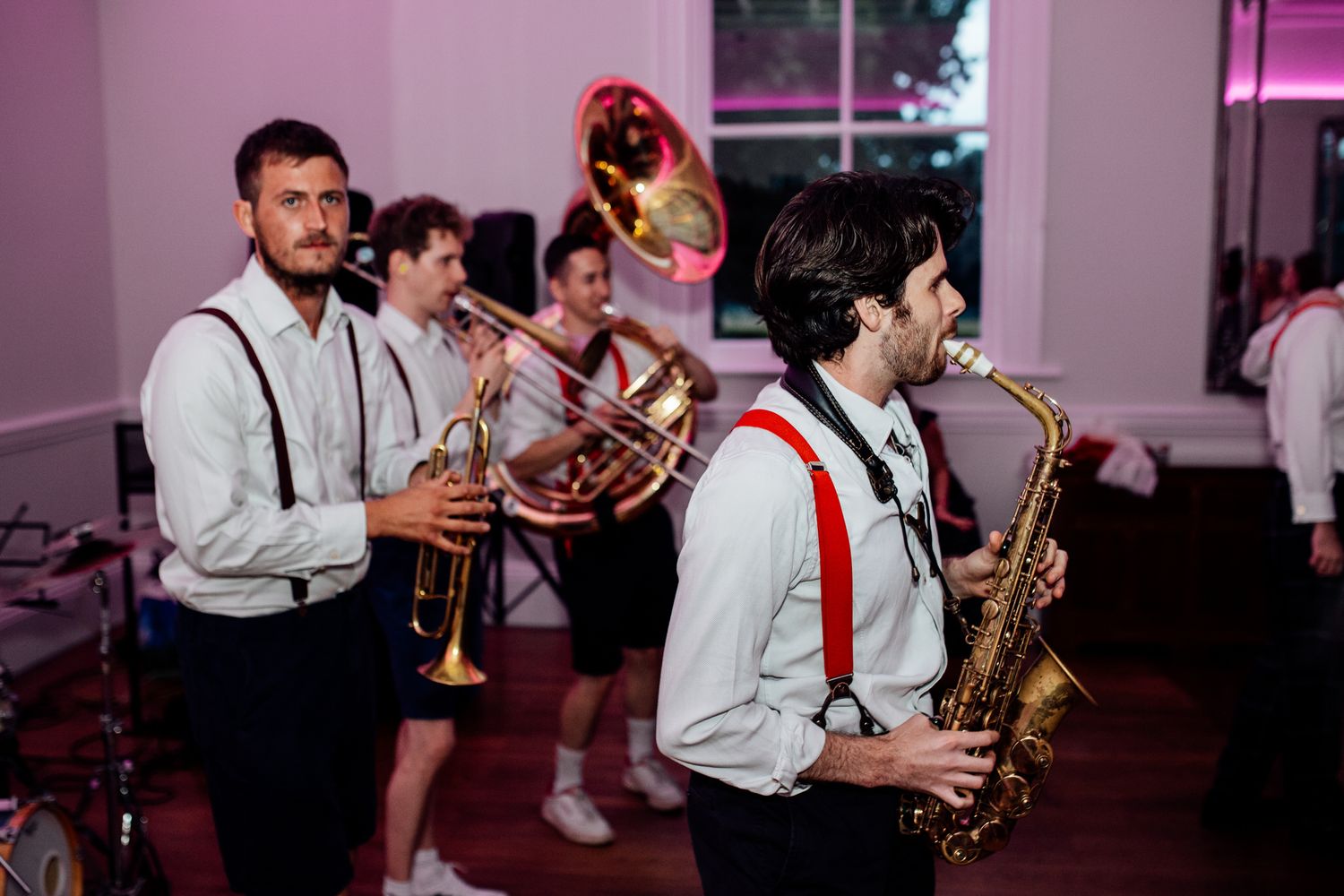 Musicians playing saxophones and brass instruments during a wedding reception performance.