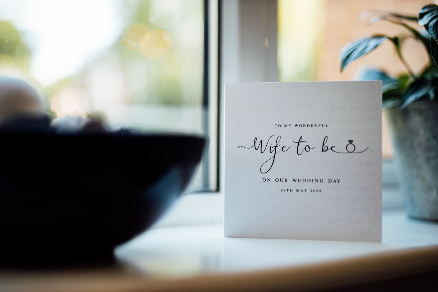 Elegant wedding stationery card reading 'wife to be' near window.