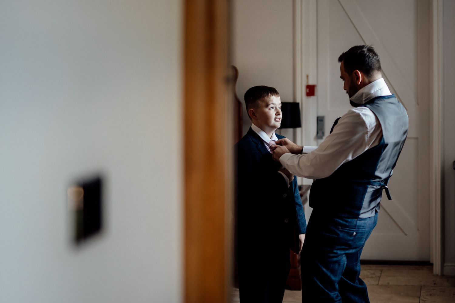 Candid getting ready moments in a bright indoor space with formal attire.