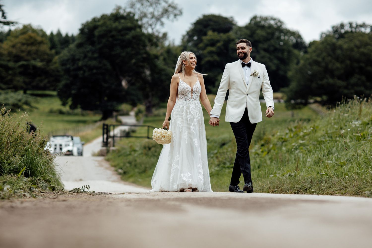 Newlyweds strolling through scenic garden pathways on their wedding day.