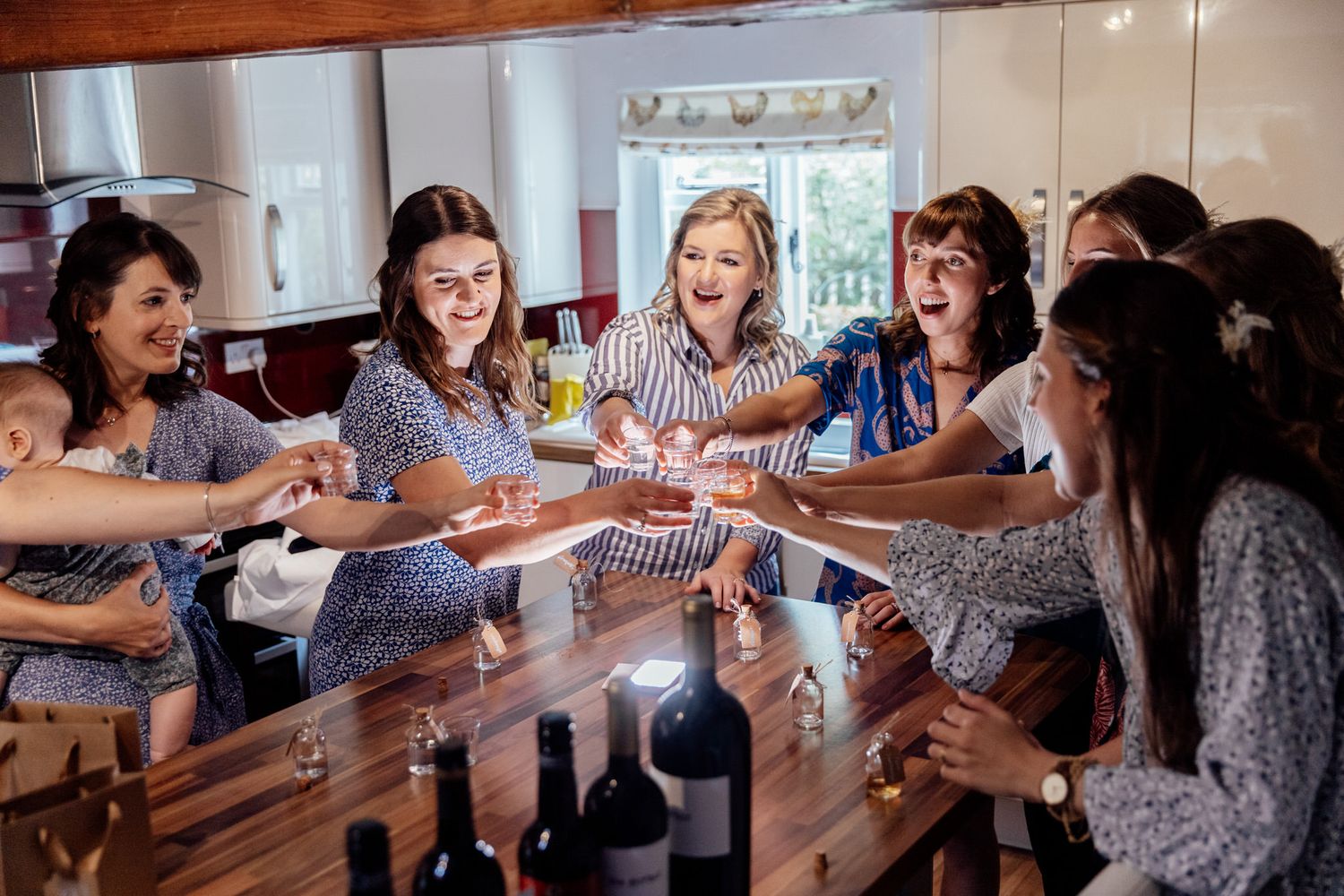 Wedding party guests laugh and dance together in a candid celebration moment.