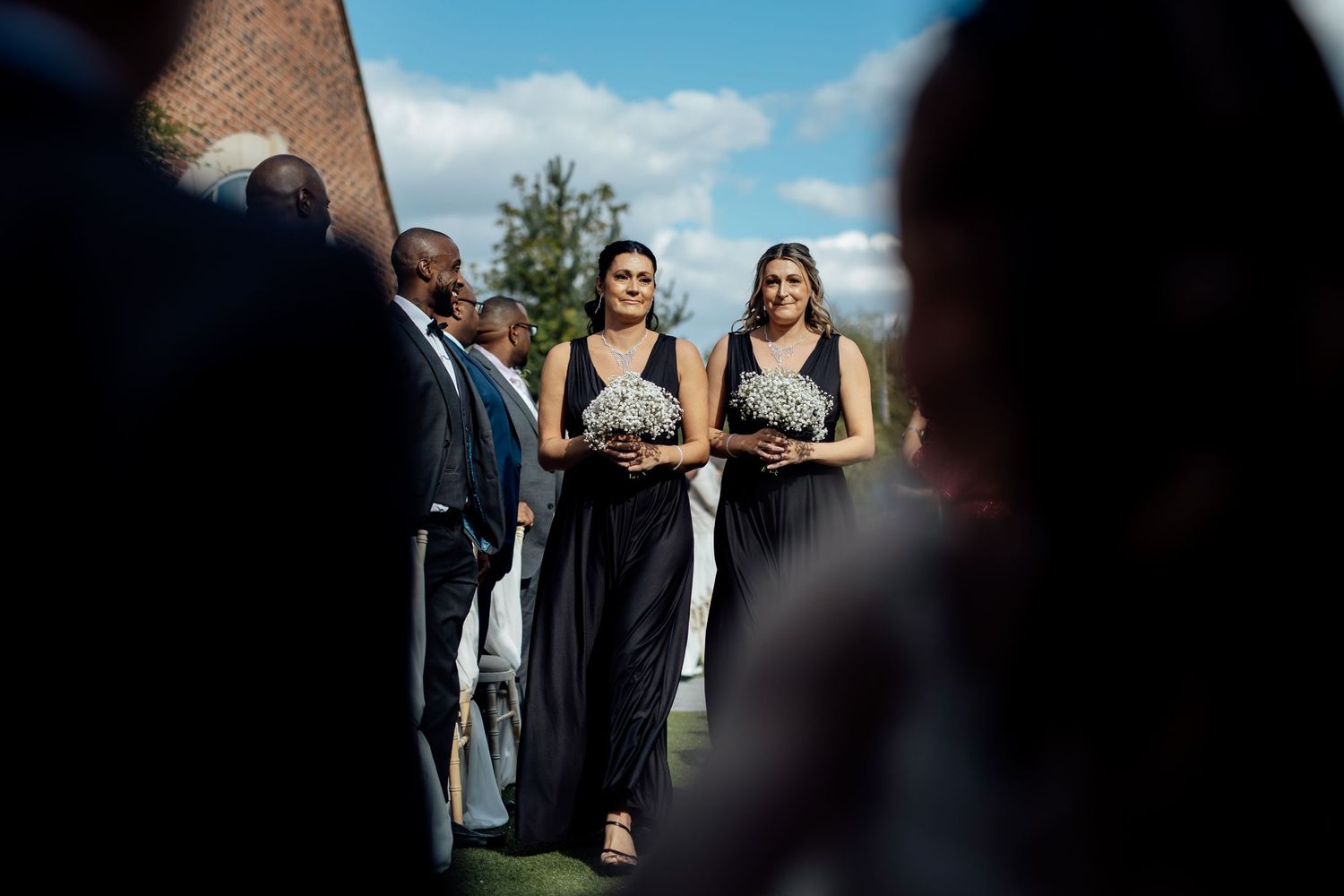Wedding party members celebrate outdoors with joyful dancing and movement.
