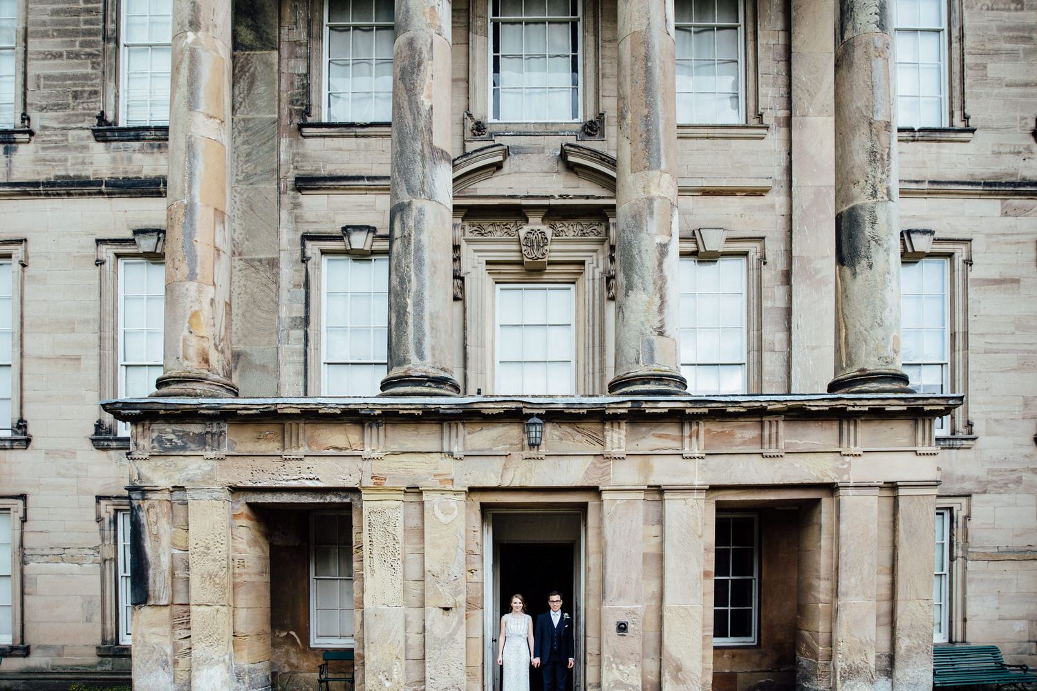 Stone facade of a grand historic building with multiple windows and classical architecture.