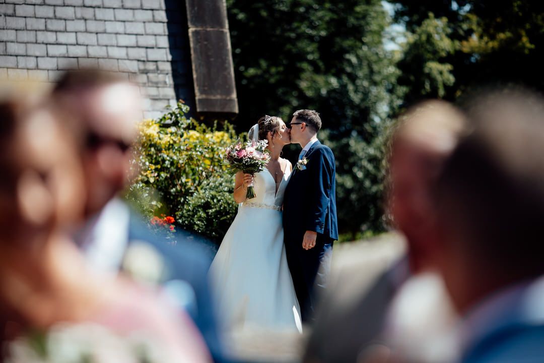 Wedding celebration captured through artistic selective focus photography in an outdoor setting.