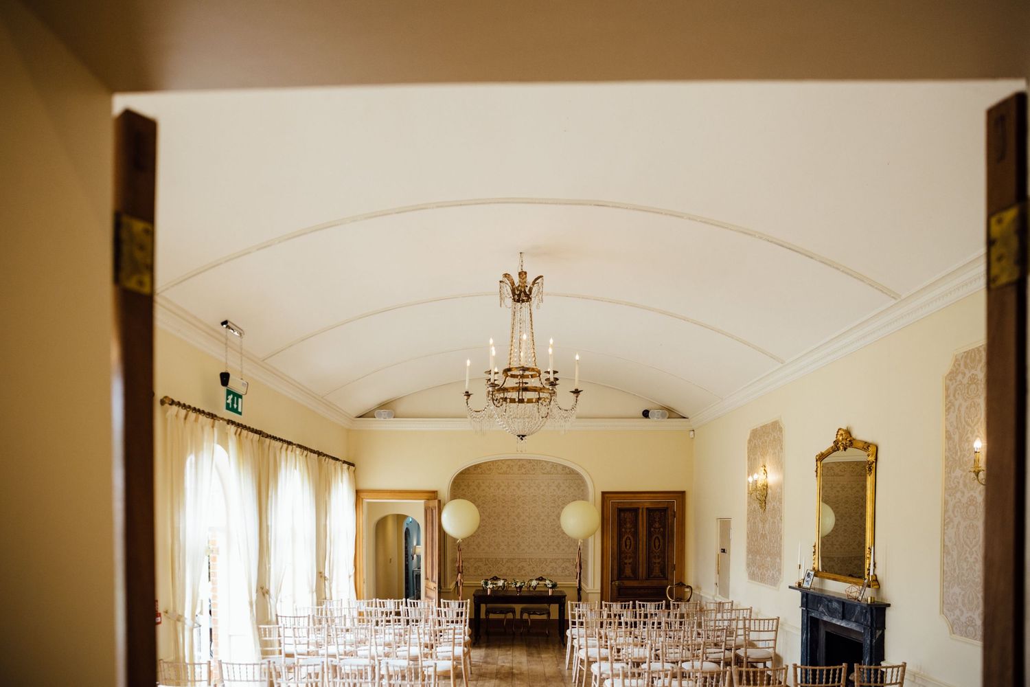 Elegant wedding venue with rows of white chairs and arched ceiling details.