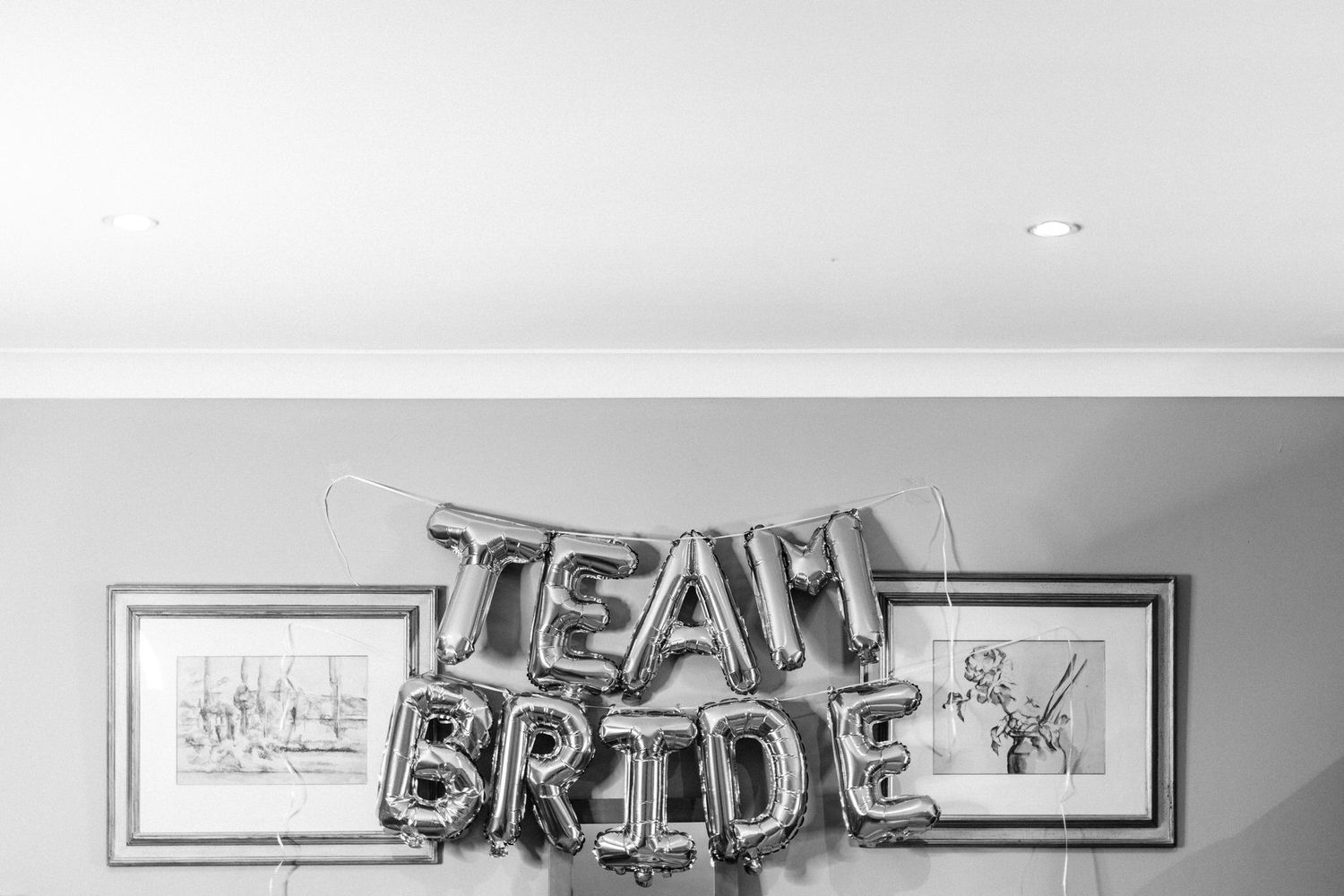 Modern wedding venue decor featuring silver balloon letters spelling 'Team Bride'.