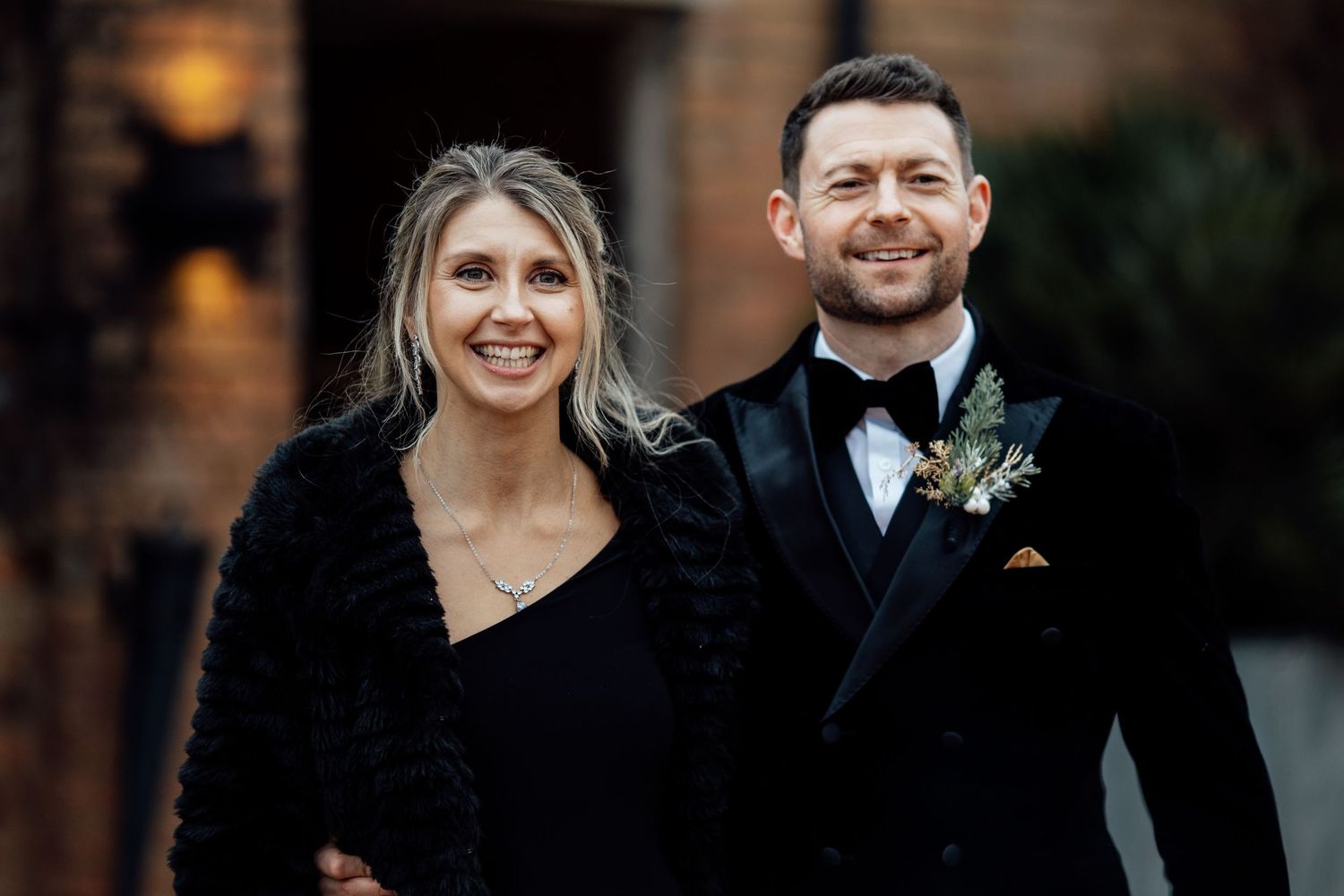 Formal couple at evening wedding event wearing black tie attire.