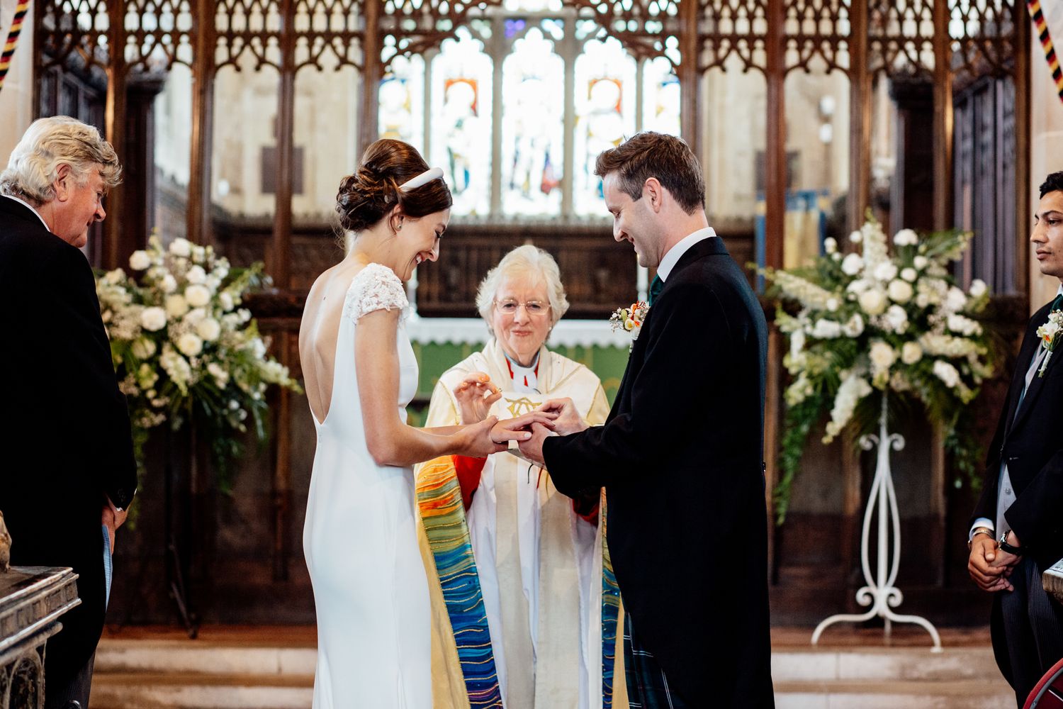 Traditional church wedding ceremony with decorative floral arrangements and gothic architecture.