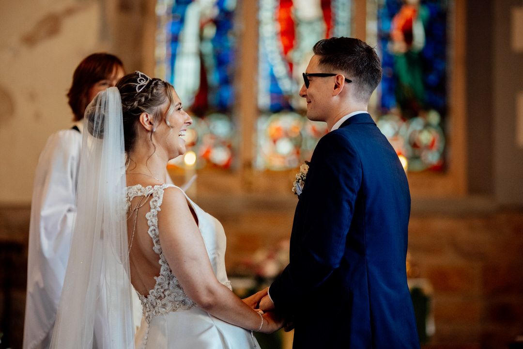 Couple sharing tender moment during church wedding ceremony.