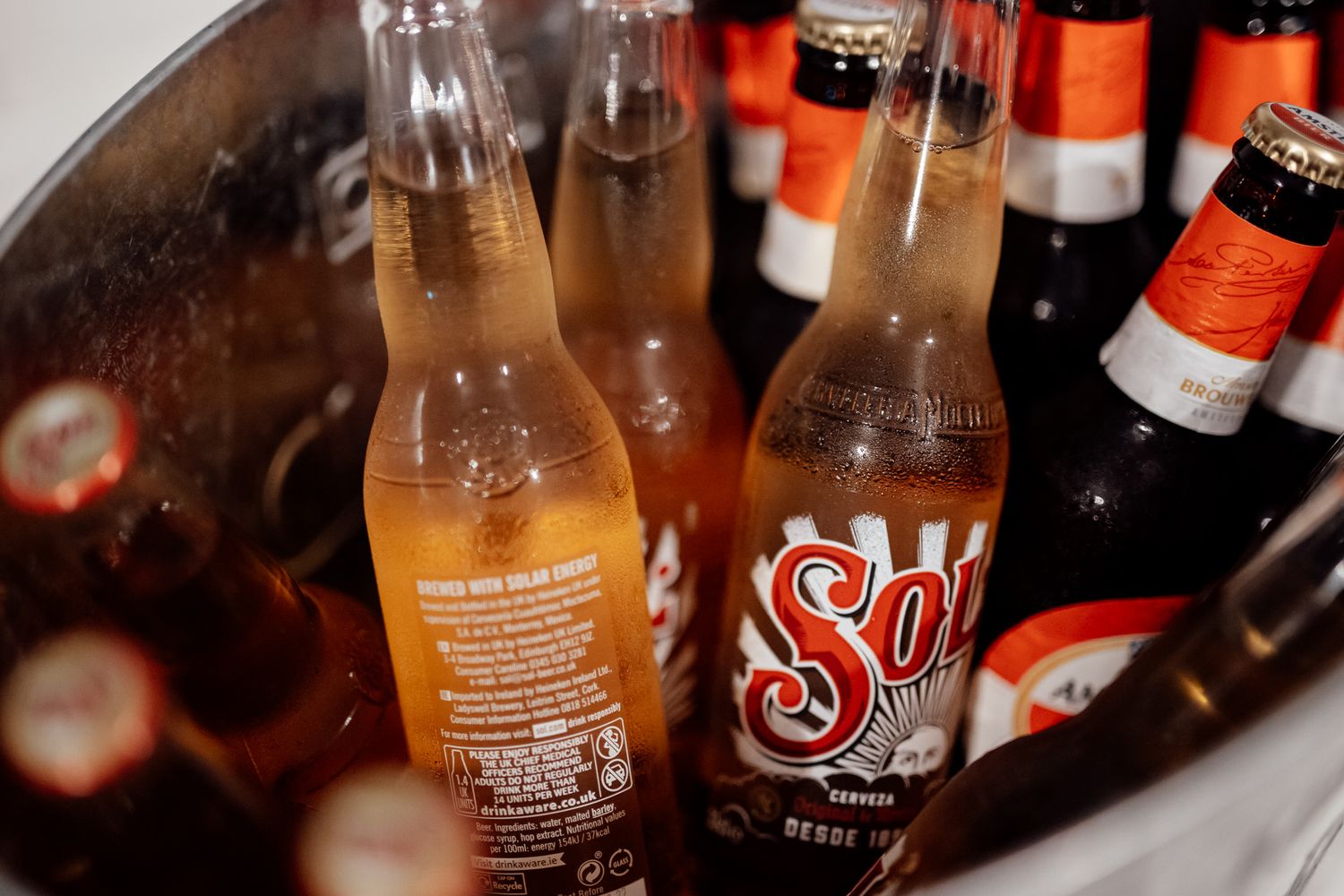 Collection of craft beer bottles arranged at wedding reception bar.
