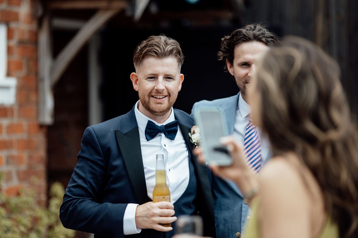 Wedding guests enjoying drinks and conversation during outdoor reception.