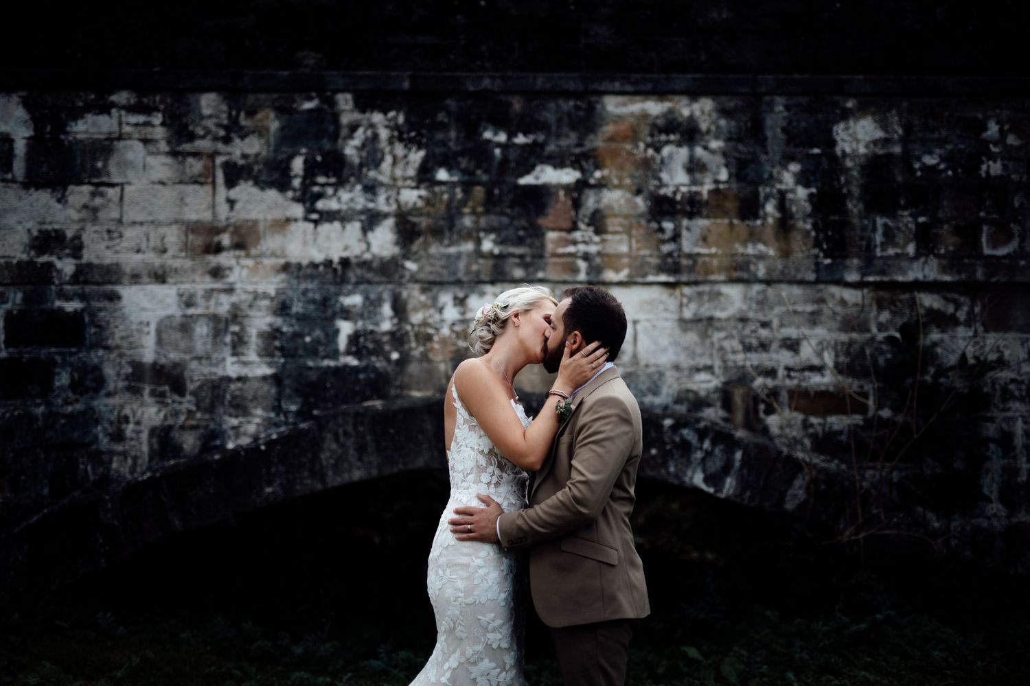 Romantic dance scene against industrial brick wall backdrop.
