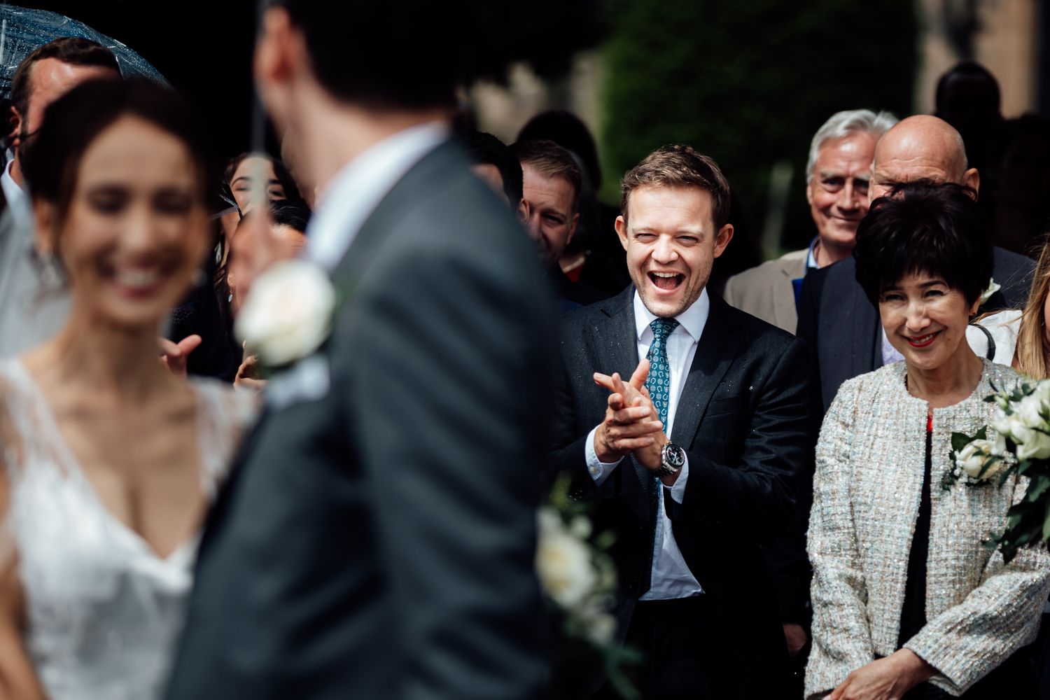 Wedding guests gathered outdoors for celebration with formal attire.