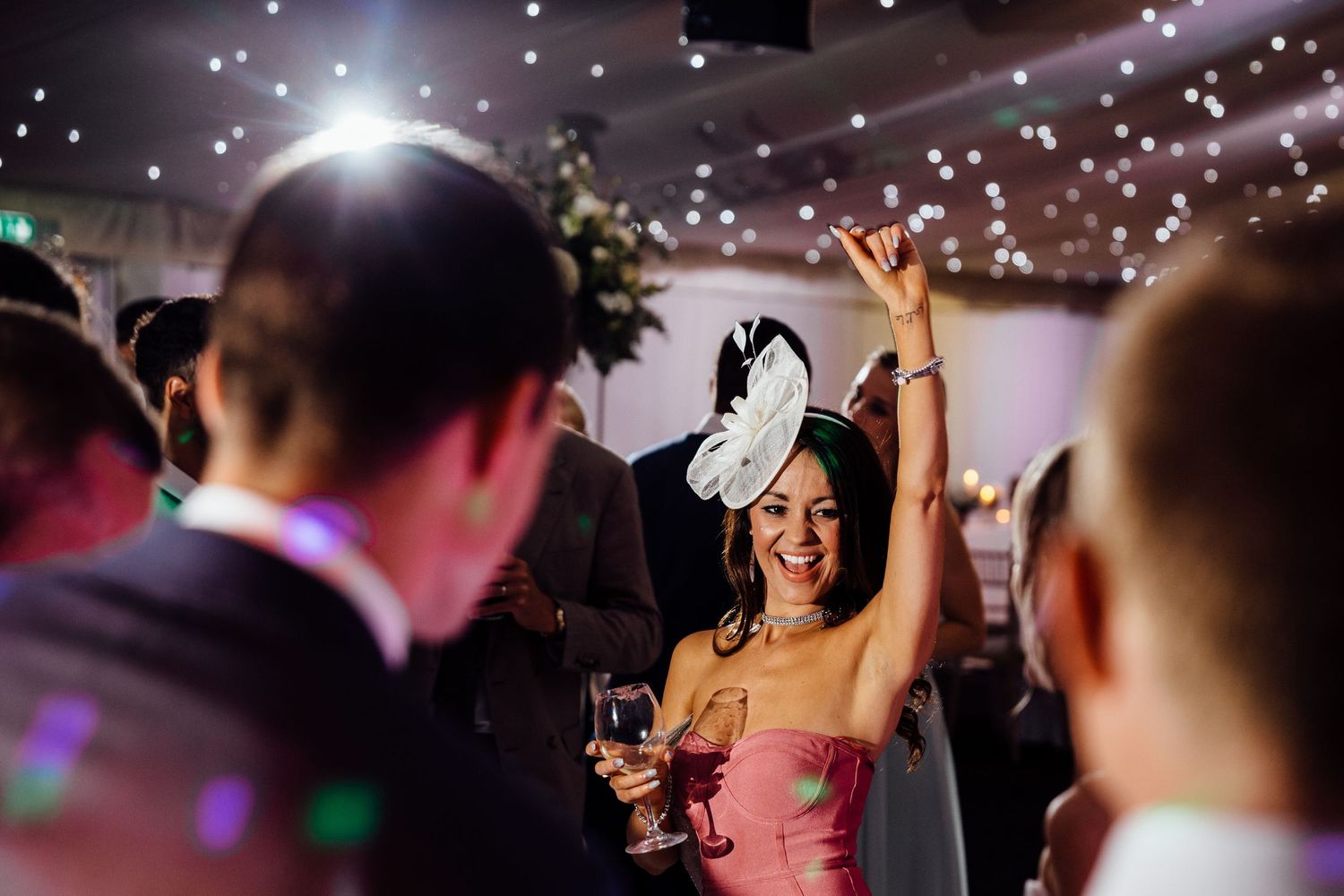 Dance floor filled with celebration under twinkling lights and disco effects.