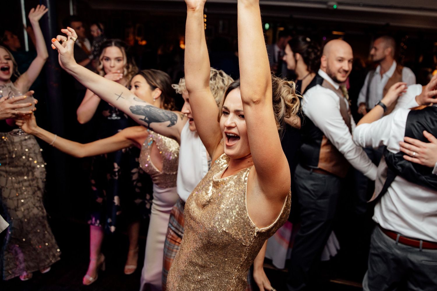 Energetic dance floor scene with party guests celebrating at evening reception.