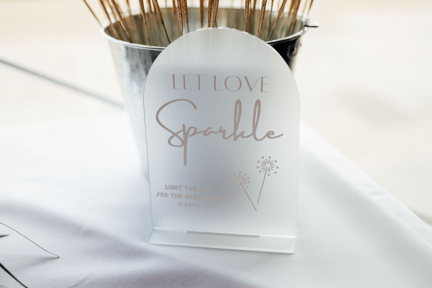 Wedding reception details with sparkle signage and elegant typography.